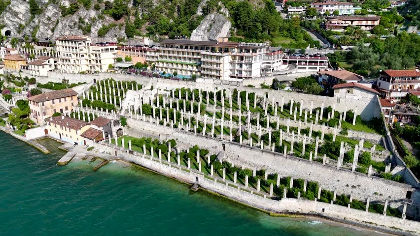 Limonaia - the lemon terraces of Limone sul Garda, Italy. Aerial 4K video footage of old lemon house in lake Garda. Drone view of lemon grove
