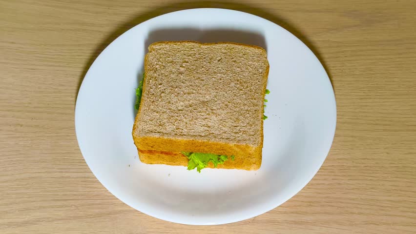 Fresh delicious vibrant tasty sandwich with crisp lettuce on a plate on a rustic wooden table. Healthy lunch, savory meal, fresh ingredients, wholesome, colorful, appetizing.