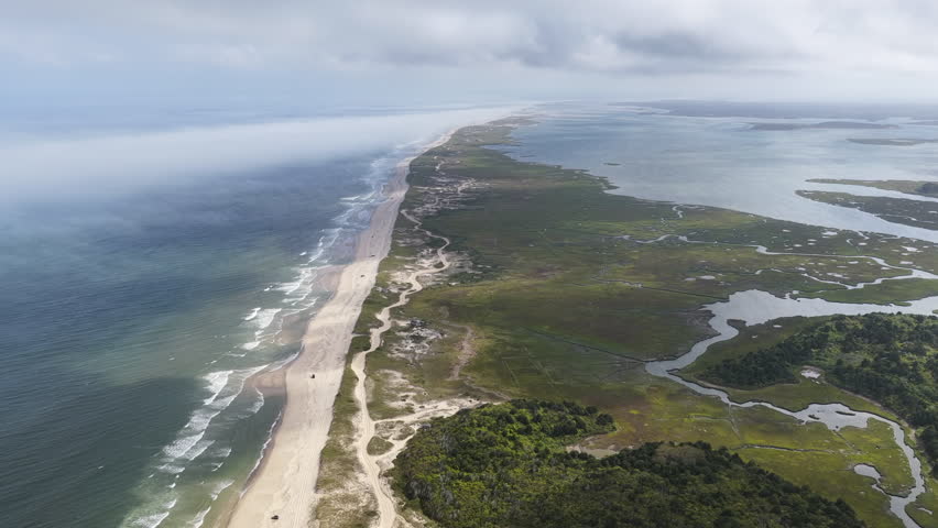Clouds drift above scenic Nauset Beach in Orleans, Cape Cod, Massachusetts. This aesthetic public beach is a popular destination for people on vacation during summer months. 