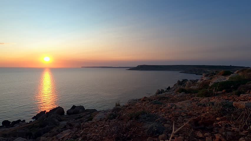 Timelapse of the sun setting over the sea horizon