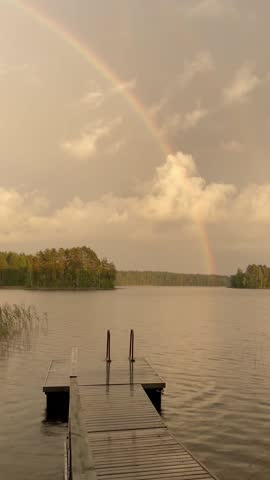 Vertical screen rainbow above lake reflecting on surface serene atmosphere pure landscape natural beauty unique weather phenomenon peaceful outdoor scene stock footage