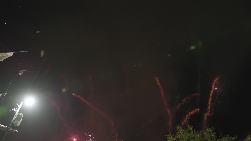 Fireworks Spark Through Smoke Above Festival Crowd in Mexico Night. High quality 4K footage