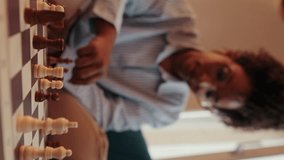 Vertical video,A person plays chess on a couch. The focus is on fallen chess pieces in the foreground, emphasizing loss and defeat. - Powered by Shutterstock - Get 15% off with code: PIKWIZARD15