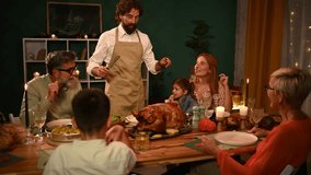 Multigenerational family warmly gathering around dining table, carefully carving traditional roast turkey during festive thanksgiving celebration at home - Powered by Shutterstock - Get 15% off with code: PIKWIZARD15