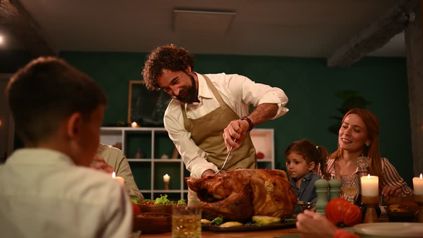 Family gathering around dining table while father skillfully carving golden roasted turkey, generations sharing festive thanksgiving meal with joy and warmth