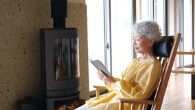 Senior woman reading in a wheelchair in front of a fireplace - Powered by Shutterstock - Get 15% off with code: PIKWIZARD15