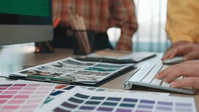 A vibrant creative workspace featuring hands typing on a keyboard, colorful swatches, and a computer displaying design elements, emphasizing collaboration and innovation. SACTR - Powered by Shutterstock - Get 15% off with code: PIKWIZARD15