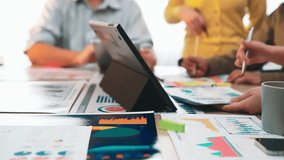 A diverse group of professionals engaged in a collaborative meeting, discussing data analysis and sharing ideas with laptops, charts, and visual aids in a bright workspace. SACTR - Powered by Shutterstock - Get 15% off with code: PIKWIZARD15