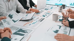 A diverse business team collaborates around a conference table, focusing on data charts and digital displays, fostering strategic planning and insightful discussions. SACTR - Powered by Shutterstock - Get 15% off with code: PIKWIZARD15