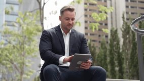 Close up of business people working on tablet while sitting at green city. Low angle camera of manager using his tablet to browsing and searching financial data analysis while remote working. Urbane. - Powered by Shutterstock - Get 15% off with code: PIKWIZARD15