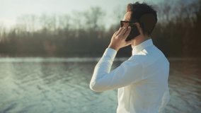 Businessman Talking On Smartphone, Outdoor Business Communication Professional On Call. Remote Work Lifestyle, Corporate Success, Digital Nomad, Sunny Day. Business Trip, Wireless Communication - Powered by Shutterstock - Get 15% off with code: PIKWIZARD15