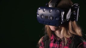 Close-up of a teenage girl wearing VR glasses and headphones, immersed in virtual reality while playing a game in a game studio. The girl is enjoying a simulation game through a VR headset. - Powered by Shutterstock - Get 15% off with code: PIKWIZARD15