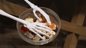 Creative Halloween candy bowl with skeleton hand and gummy treats - Powered by Shutterstock - Get 15% off with code: PIKWIZARD15