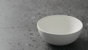 Slow motion pour pumpkin cream soup in white bowl on terrazzo countertop - Powered by Shutterstock - Get 15% off with code: PIKWIZARD15