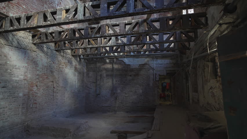 Enormous iron supports reinforce massive brick walls of old building. Strong reinforcements dominate brick structure. Old house renovation