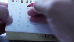 A person marks a calendar with a red marker, circling dates and marking deadlines and progress. Time management, planning, scheduling Important days, Deadlines
 - Powered by Shutterstock - Get 15% off with code: PIKWIZARD15