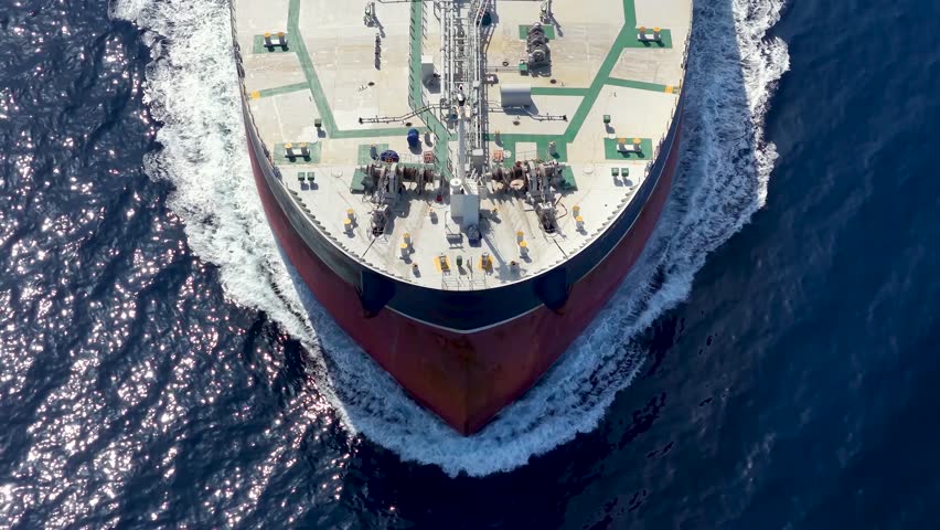Aerial overhead view of a bow from a large oil or chemical goods tanker ship sailing with speed over the ocean