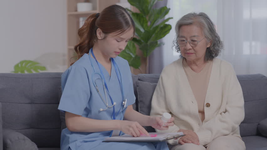 Asian young Internist and Elderly patient during medical consultation. Doctor working in the office and listening patient, explaining her symptoms, prescription, senior people healthcare concept