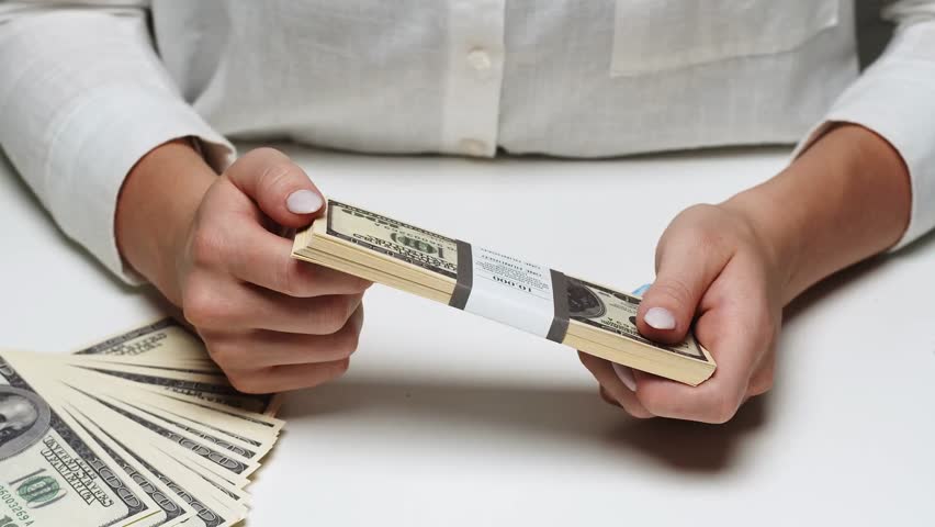 Businessman flipping through a bundle of money, illustrating wealth, finance, business success, financial transactions, and corporate lifestyle.