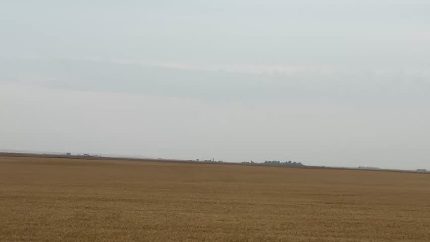 Driving past wide open farmland with agricultural fields and rural prairie scenery, showcasing farming landscape, agriculture lifestyle, and countryside beauty in Alberta, Canada.