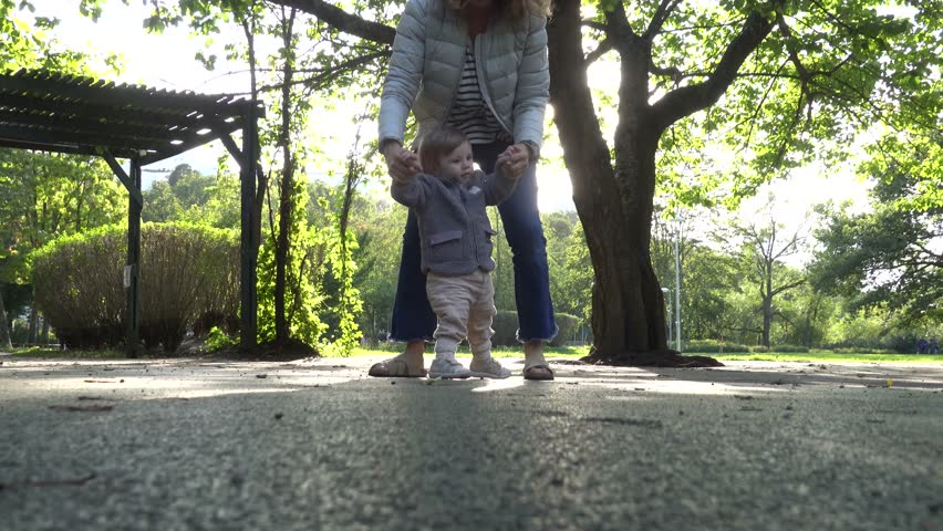 Stockholm, Sweden A grandmother and her one-year-old granddaughter walking in the park.  