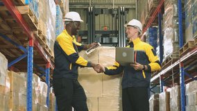 Two male employees working together in a warehouse show handshake cooperation share duties check stock drive forklift receive and deliver goods check stock according to the factory industry system. - Powered by Shutterstock - Get 15% off with code: PIKWIZARD15