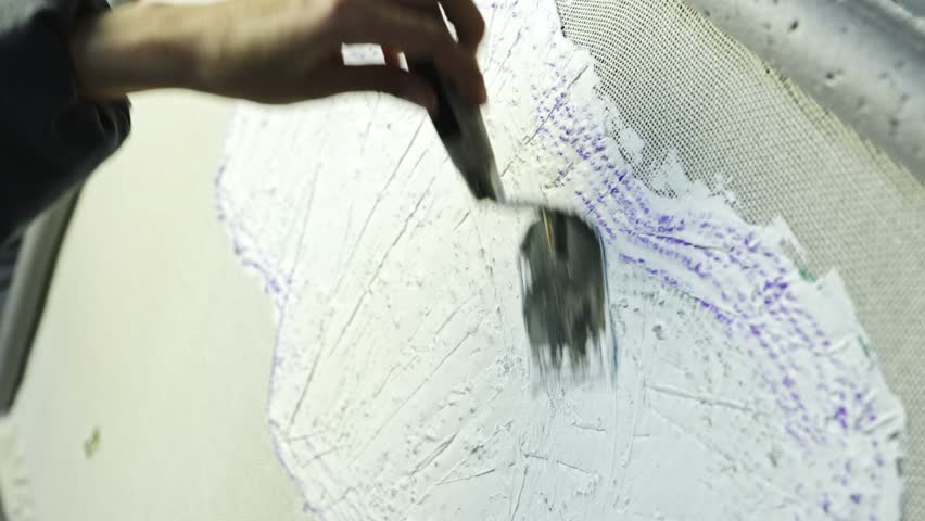 Craftswoman applying backing glue on carpet canvas