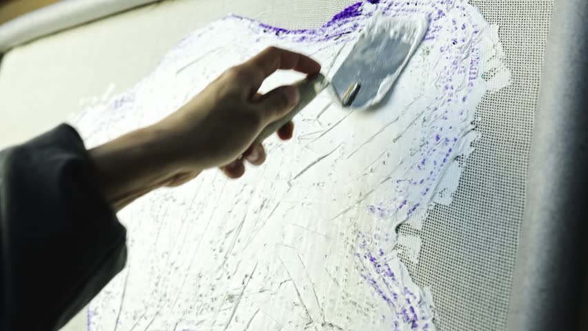 Slow motion of craftswoman applying fixing glue on rug, carpet making concept