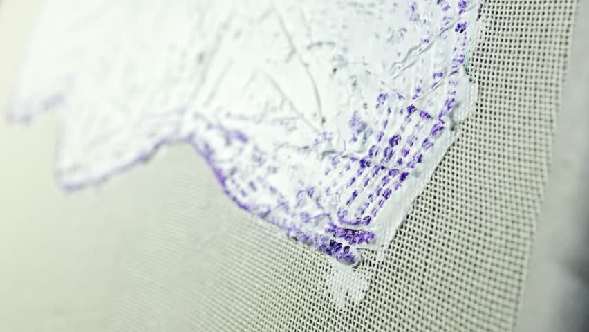 Slow motion of craftswoman applying backing glue on carpet