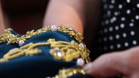 Detailed shots of hands meticulously creating intricate gold and pearl embroidery on fabric, followed by hands setting up a modern sewing machine for textile work. Perfect for showcasing craftsmanship - Powered by Shutterstock - Get 15% off with code: PIKWIZARD15