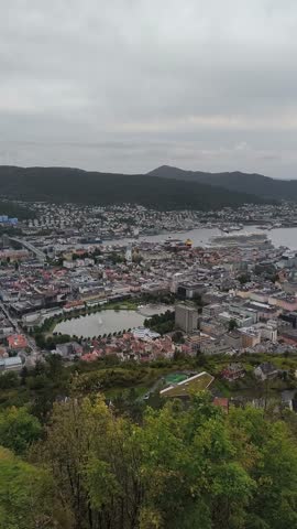 Scenic views of Bergen, Norway, with colorful wooden houses, fjords, and mountains, filmed at sunset, at night, and from mountain viewpoints.