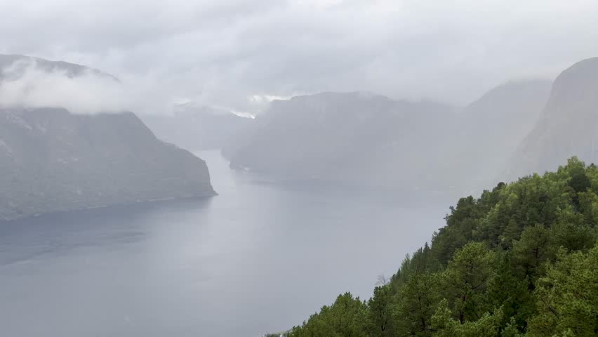 Majestic Norwegian fjords captured from a boat, from the road, and from above, under sun and rain.