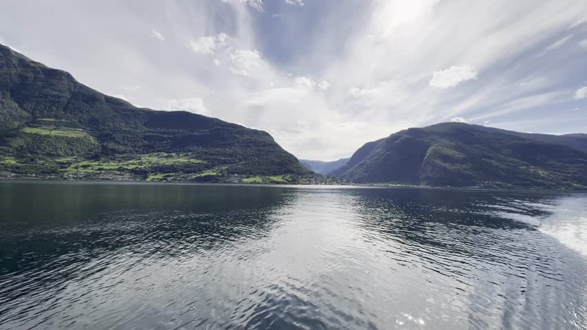 Majestic Norwegian fjords captured from a boat, from the road, and from above, under sun and rain.