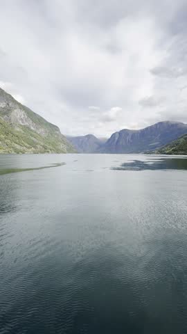 Majestic Norwegian fjords captured from a boat, from the road, and from above, under sun and rain.