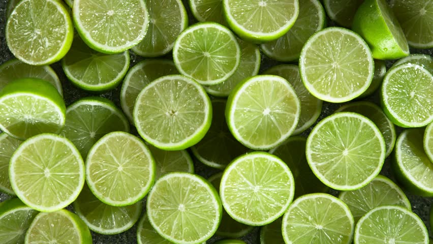 Super Slow Motion Shot of Fresh Limes Falling into Water at 1000 fps