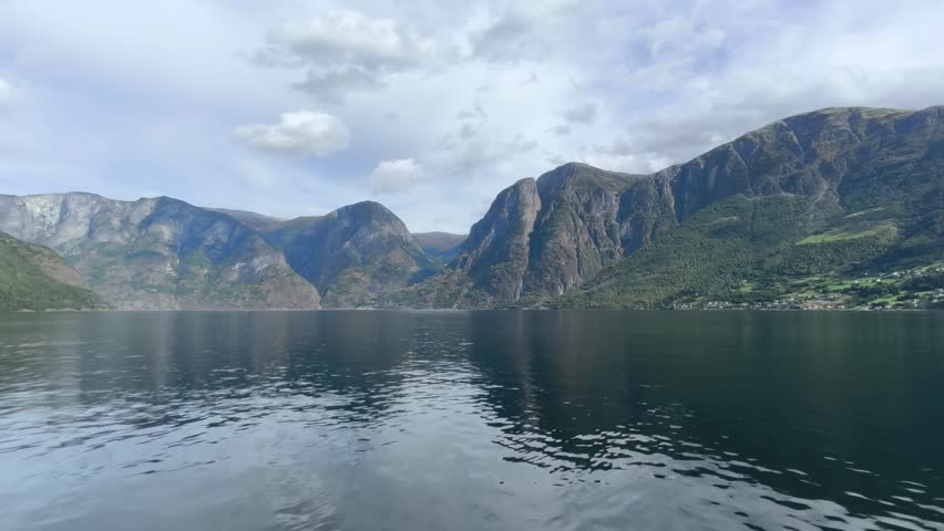 Majestic Norwegian fjords captured from a boat, from the road, and from above, under sun and rain.