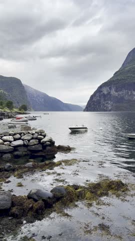 Majestic Norwegian fjords captured from a boat, from the road, and from above, under sun and rain.