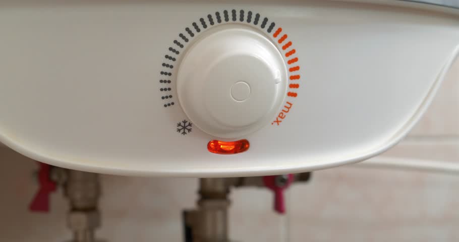 Boiler with temperature regulator for heating cold water. Red light indicator comes on - boiler works to heat the water. Boiler heats water from cold water supply system