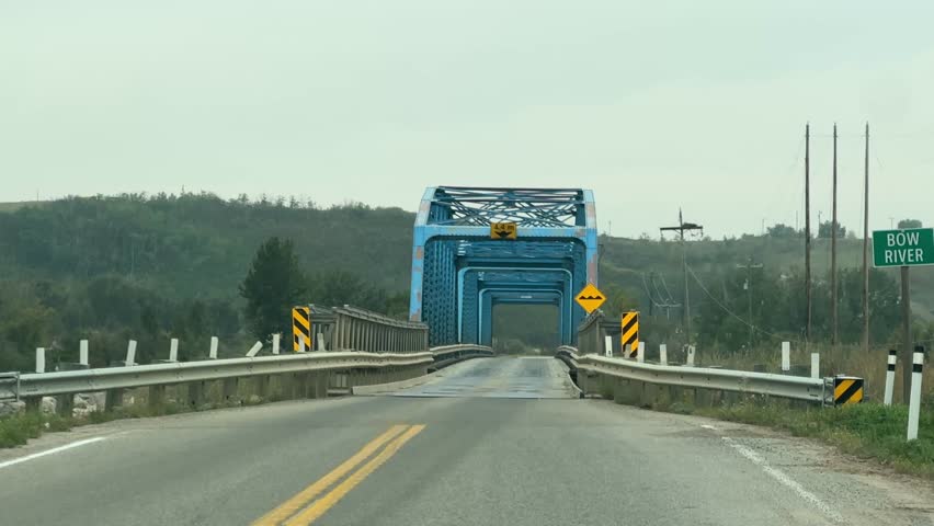 Driver’s point of view of highway driving in Canada, captured from inside a moving vehicle during daylight hours, showing road lines, open skies, and rural landscape surroundings