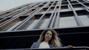 A young woman gazes upward, lost in thought on an urban high-rise balcony. The city architecture frames her contemplative mood. Young Woman Contemplating on Urban Building Balcony - Powered by Shutterstock - Get 15% off with code: PIKWIZARD15