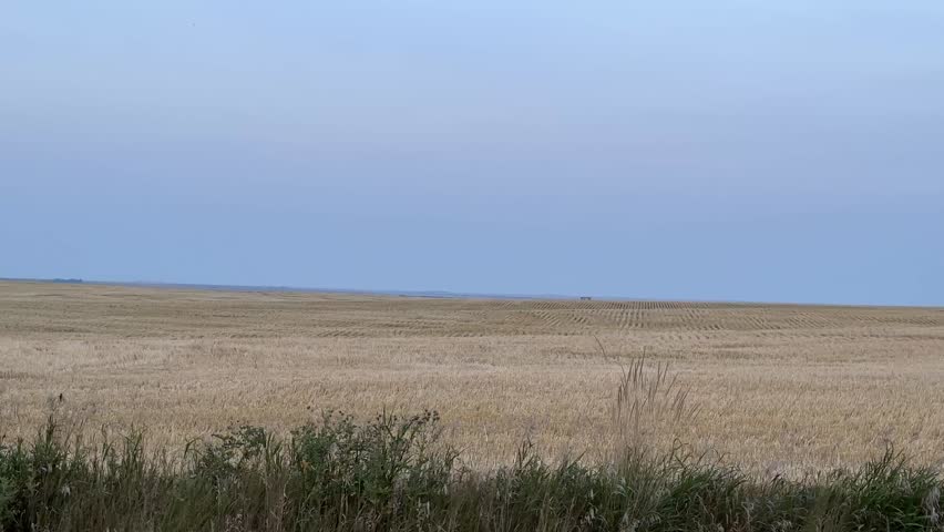 Scenic Alberta drive showing farmland fences, wide agricultural fields, and prairie landscapes, representing rural country living and farming heritage.