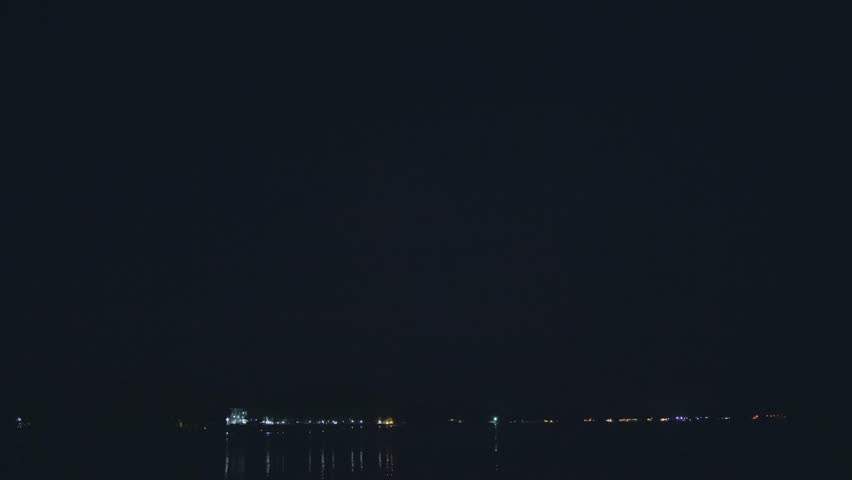Lightning over the sea at night. Tropical thunderstorm, lightning flashes over the evening sky, thunderstorm is approaching