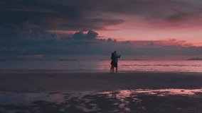 Honeymoon couple in love dancing at sunset by the sea enjoying romantic seaside vacation. Couple enjoying romantic sunset by the sea dancing. Beautiful pink tropical sunset. - Powered by Shutterstock - Get 15% off with code: PIKWIZARD15