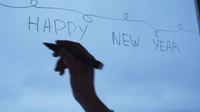 Painted window with white marker. HAPPY NEW YEAR AND MERRY CHRISTMAS text decoration on big clear window. Snowy winter outside. Zero waste decor conscientious celebration - Powered by Shutterstock - Get 15% off with code: PIKWIZARD15