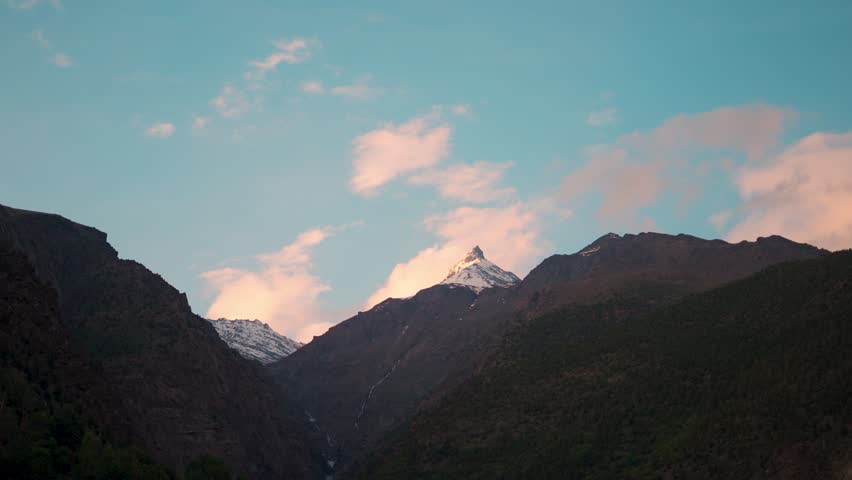 4K shot of Orange clouds above the Himalayan mountain range as seen during the sunset in Autumn season at Keylong in Lahaul Valley, Himachal Pradesh, India. Scenic sunset in the Himalayas.
