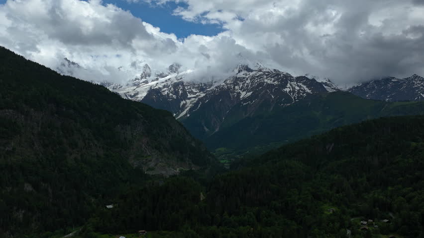 Hyperlapse drone shot of clouds moving over snowy Mount Blanc, summer in France