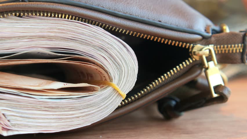 Large stack of cash visible in an unzipped bag