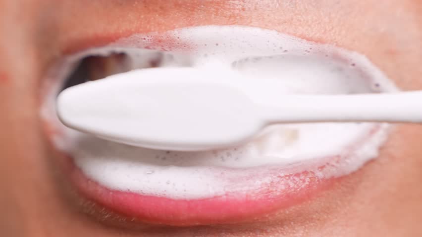 A close-up shows someone brushing their front teeth, highlighting oral hygiene. The image also reflects self-care, daily routines, dental health, prevention, and the importance of healthy habits.
