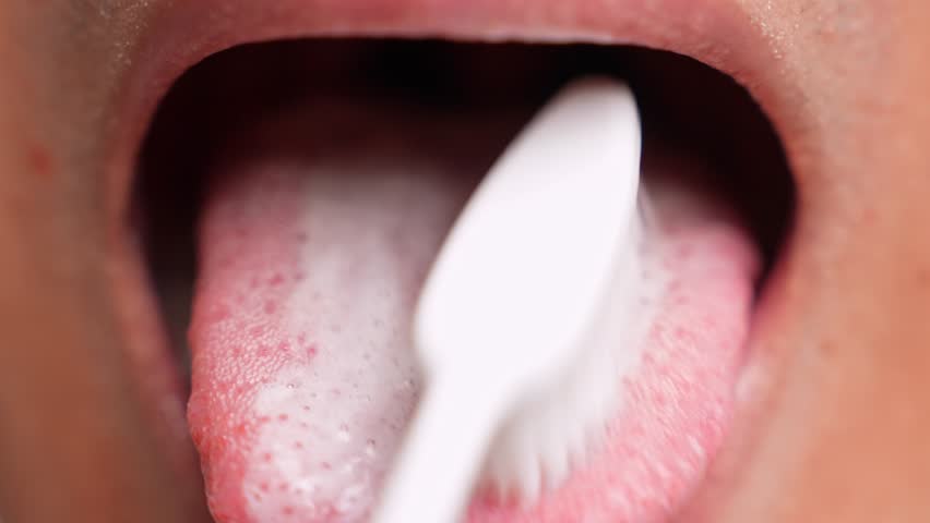 A close-up of tongue brushing highlights the importance of complete oral hygiene. Also conveys thorough self-care, freshness, prevention of bad breath, healthy routines, and attention personal health.