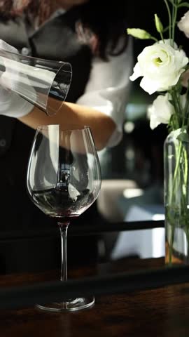 Red wine in a transparent decanter. Slow motion video, close-up. The bartender prepares wine for consumption.